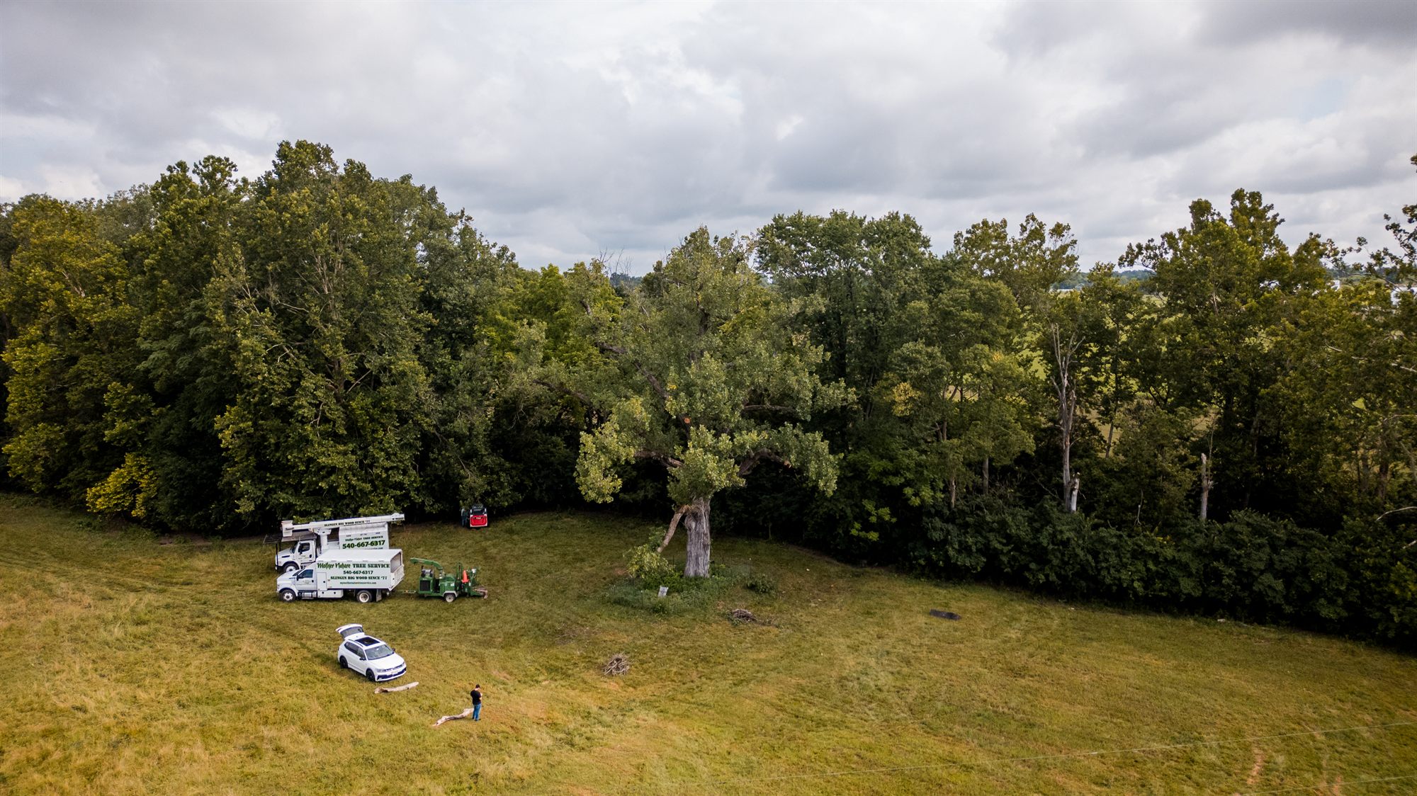 Aerial view of crew and equipment arriving at a pasture job site