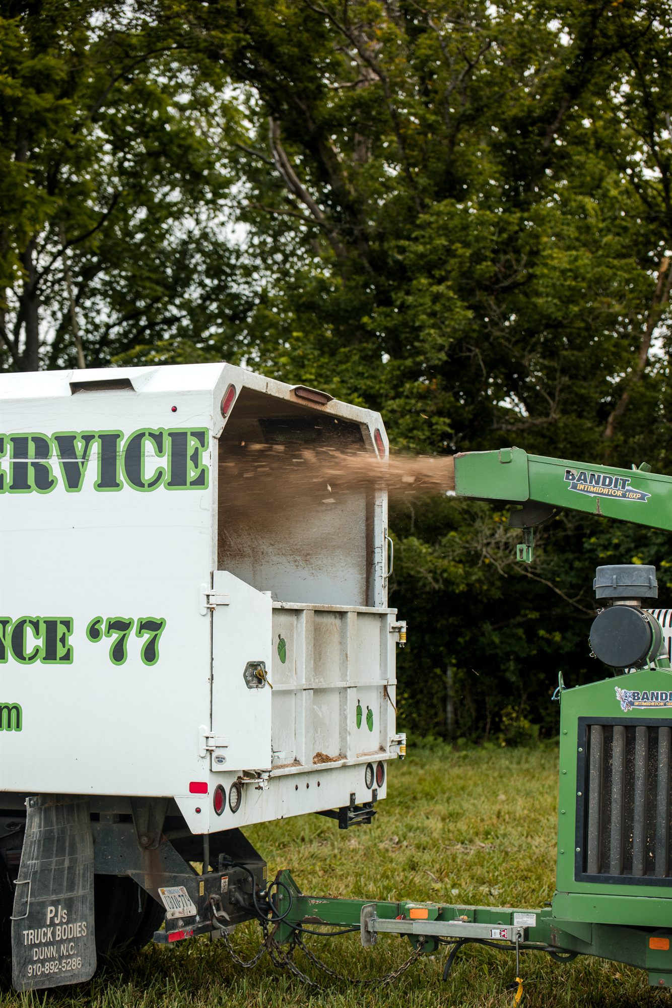 Wood chips discharging from a chipper chute into the open body of a truck